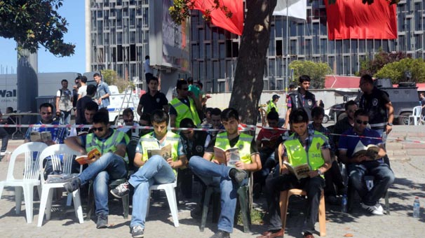 

`Duran adam`ın karşısında kitap okuyan polis


